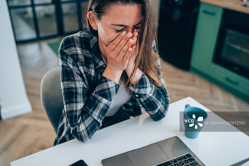 在家使用笔记本电脑的焦虑妇女图片素材