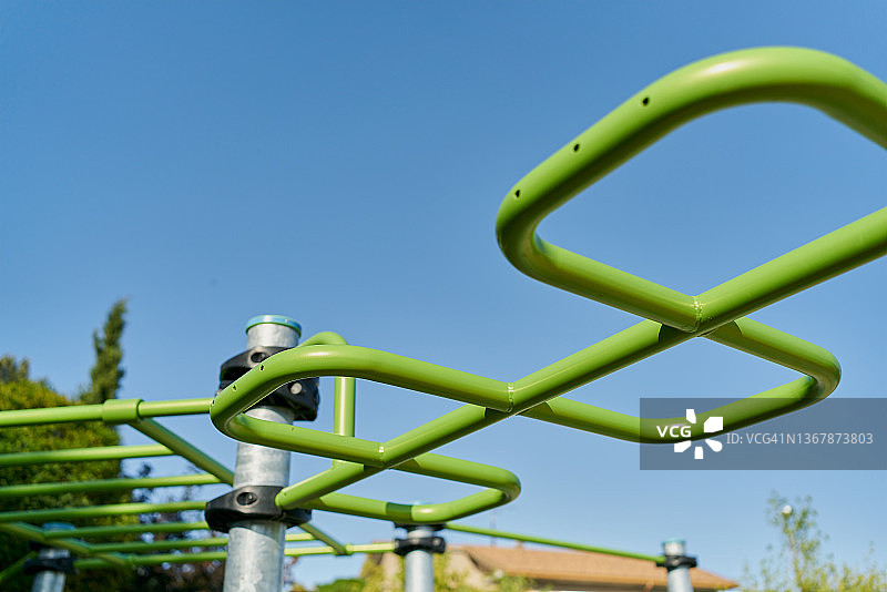 游乐场蓝色天空下的单杠仰视角度图片素材