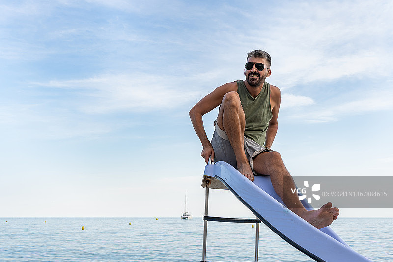 男子在海滩上用踏板船玩平底雪橇图片素材