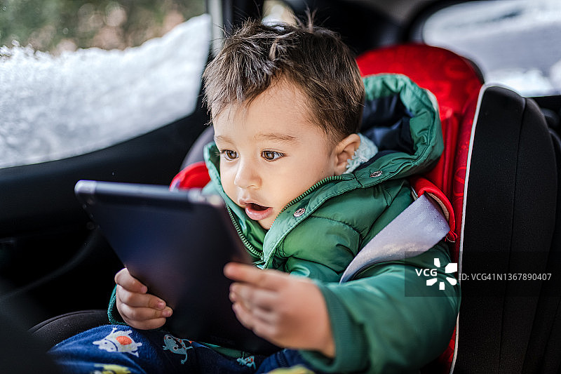 在车里玩平板电脑的男婴图片素材