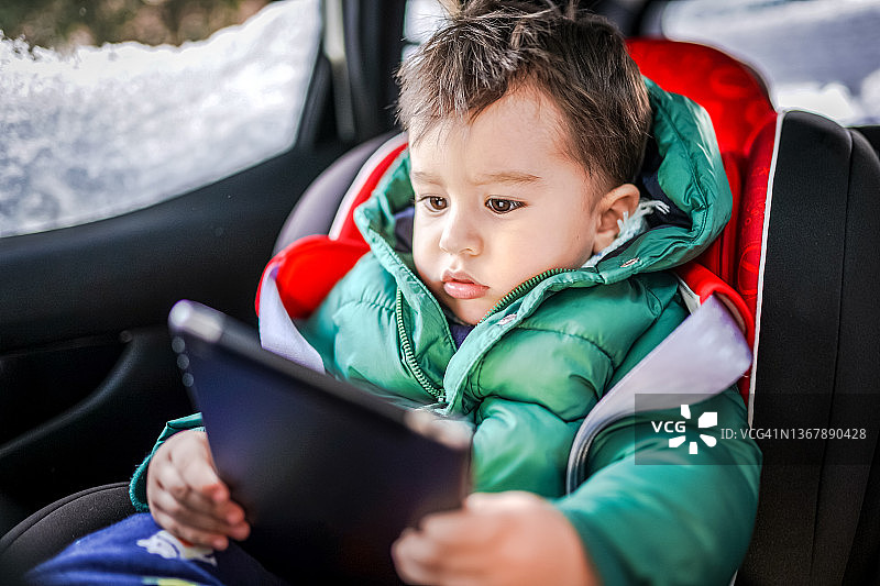 在车里玩平板电脑的男婴图片素材