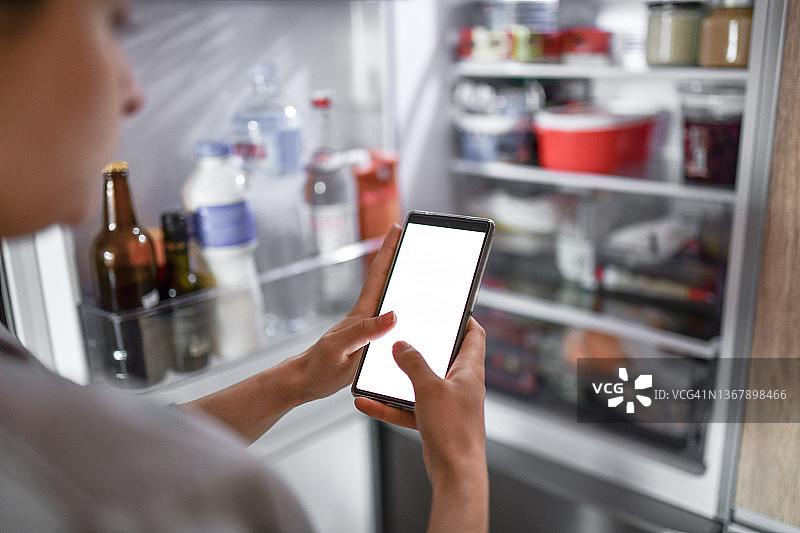 女性查看冰箱后决定在线订餐图片素材