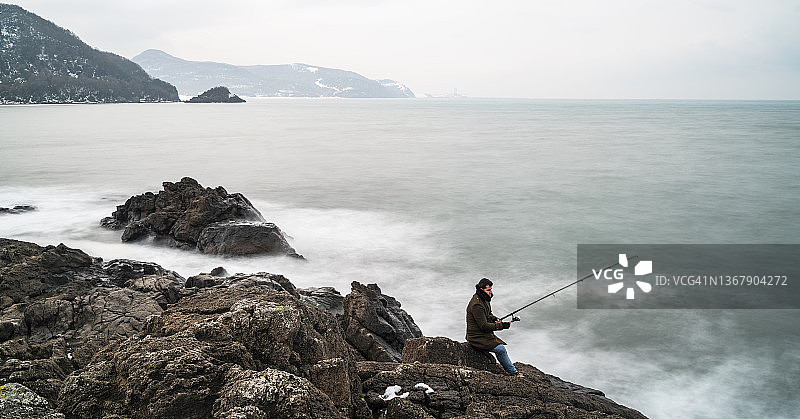 在黑海沿岸用钓竿钓鱼的男人图片素材