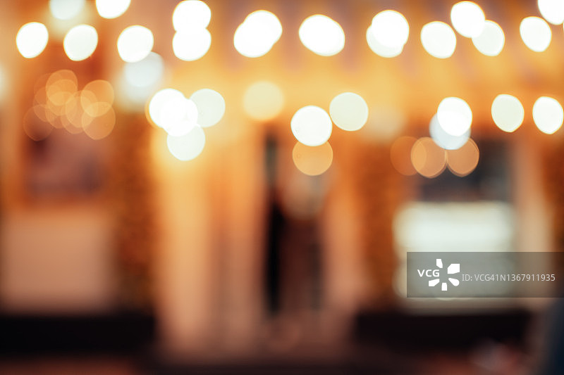 城市咖啡馆的模糊外观，装饰着节日灯饰。美丽的明亮背景，带有复制空间。正面视图图片素材