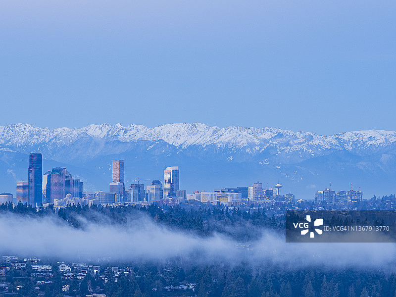 黎明时分低云下的西雅图摩天大楼和奥林匹克山脉图片素材