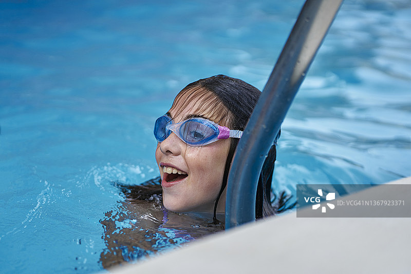 小女孩在泳池里游泳图片素材