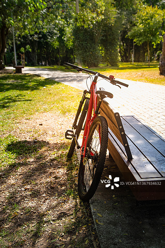 红色自行车靠在长椅上图片素材