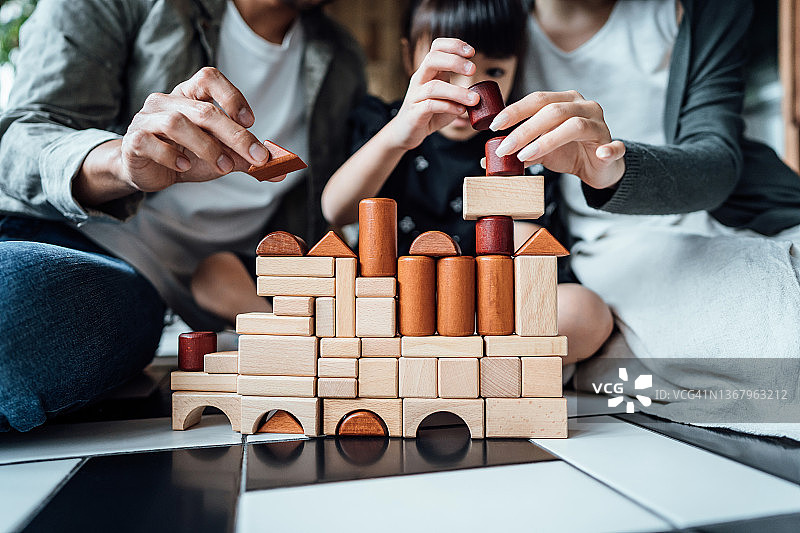 快乐的亚洲年轻家庭在地板上玩积木的特写镜头图片素材