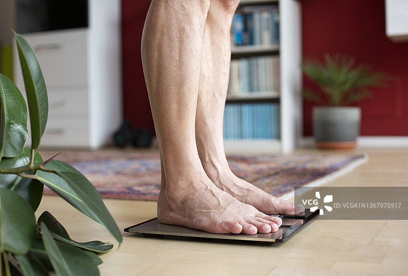 男人站在体重秤上，底部截面图片素材