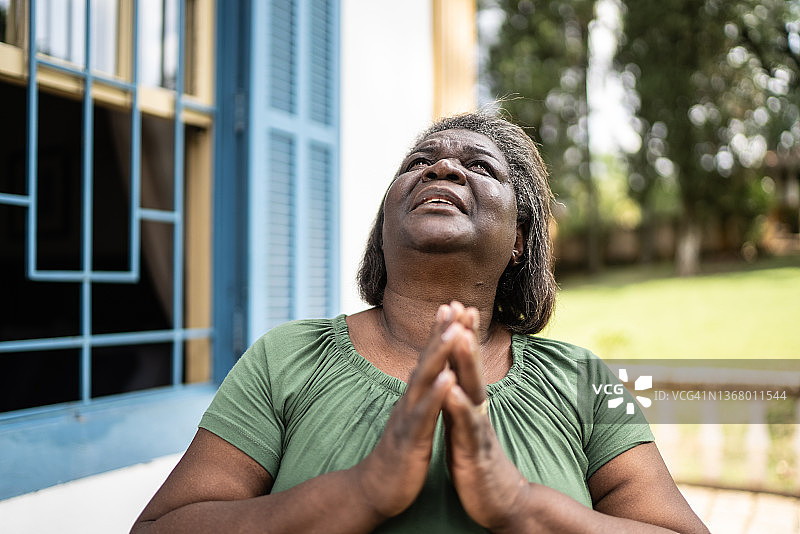 户外祈祷的焦虑老年妇女图片素材