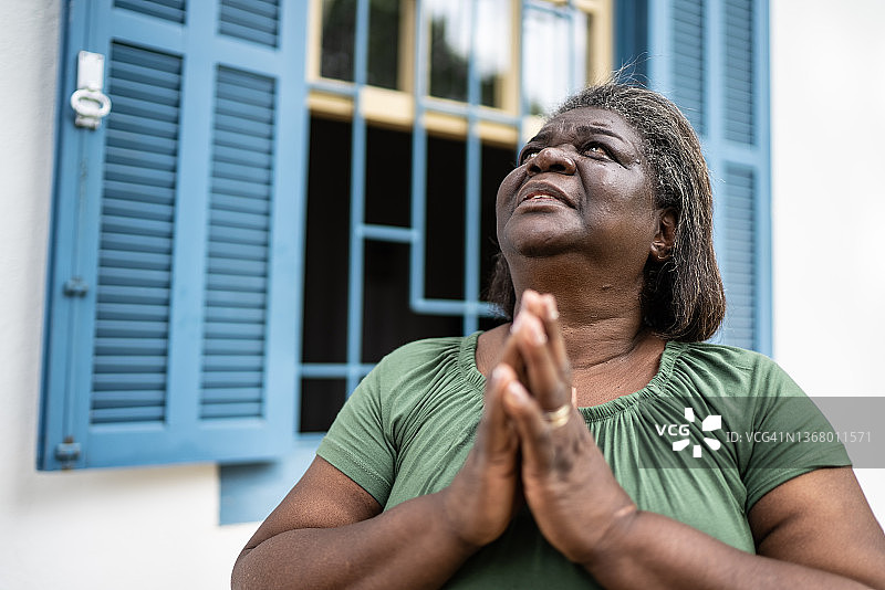 户外祈祷的焦虑老年妇女图片素材