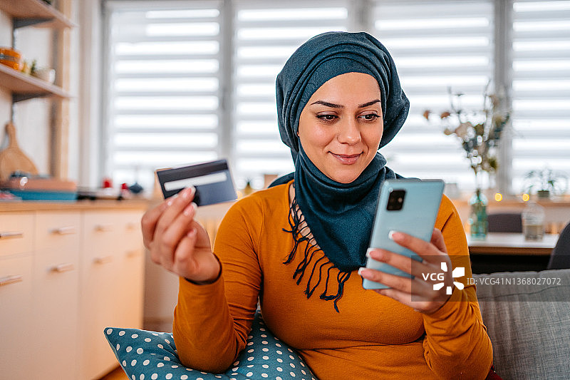 在家网上购物的年轻穆斯林女性图片素材