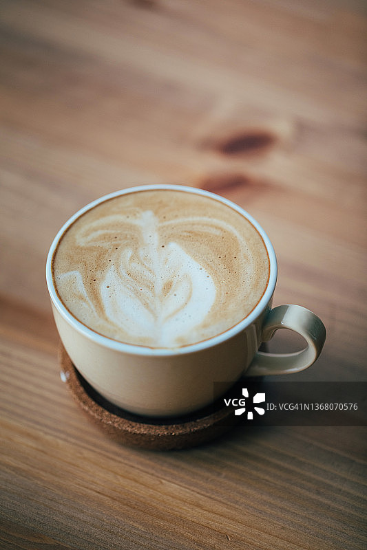 木桌上的拿铁咖啡杯图片素材