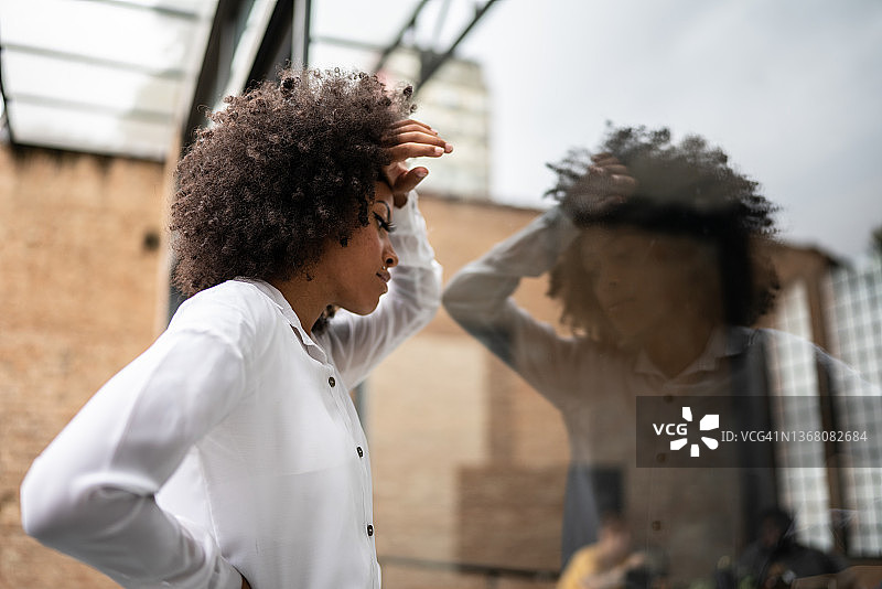 倚靠在窗边的焦虑女商人图片素材