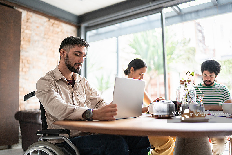 在办公室工作的残疾青年商人图片素材