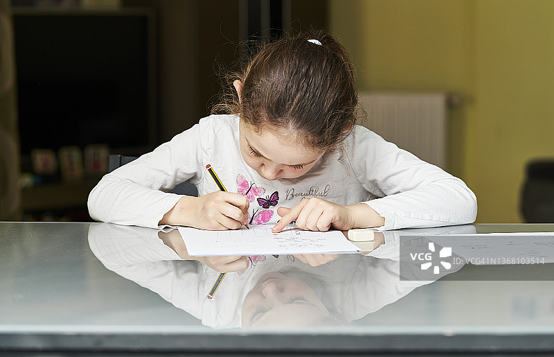 小女孩在家学习时做作业图片素材