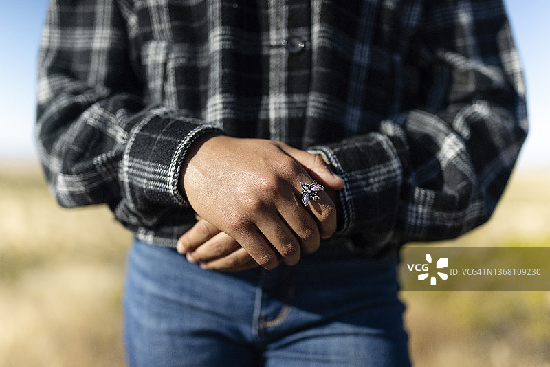 特写：戴着飞蛾戒指的年轻女孩的手图片素材