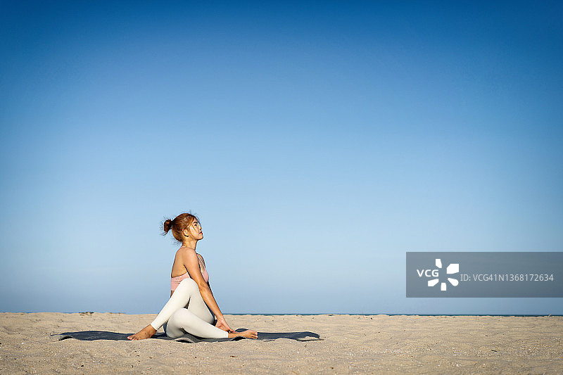 在海滩上练习瑜伽的中年亚洲女人图片素材