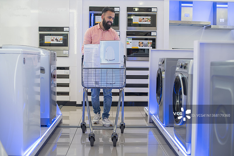 年轻人在电器商店看洗衣机图片素材