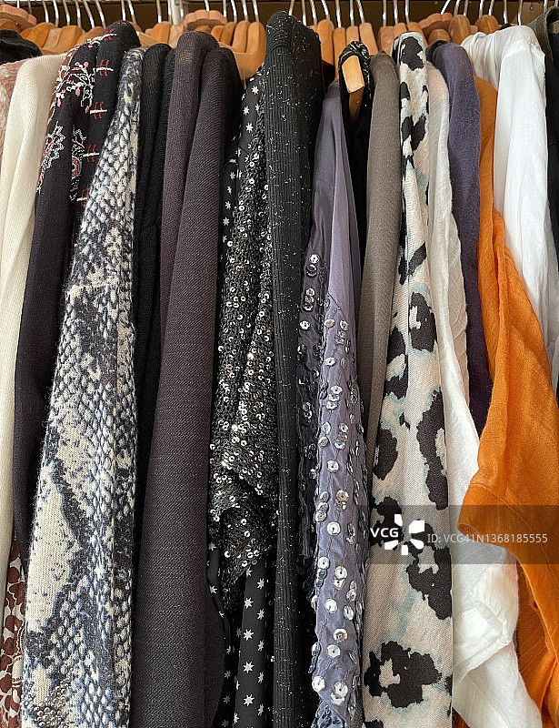 衣柜中悬挂的各式衬衫、上衣和开衫图片素材