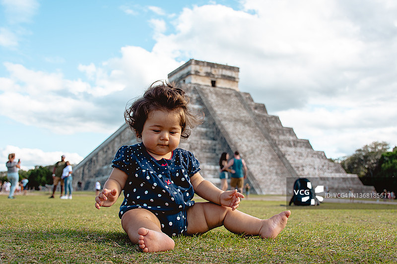 宝宝在墨西哥奇琴伊察前的草地上玩耍图片素材