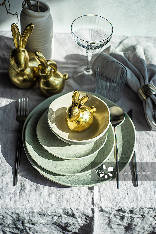 金色复活节兔子装饰品的节日复活节餐桌布置图片素材