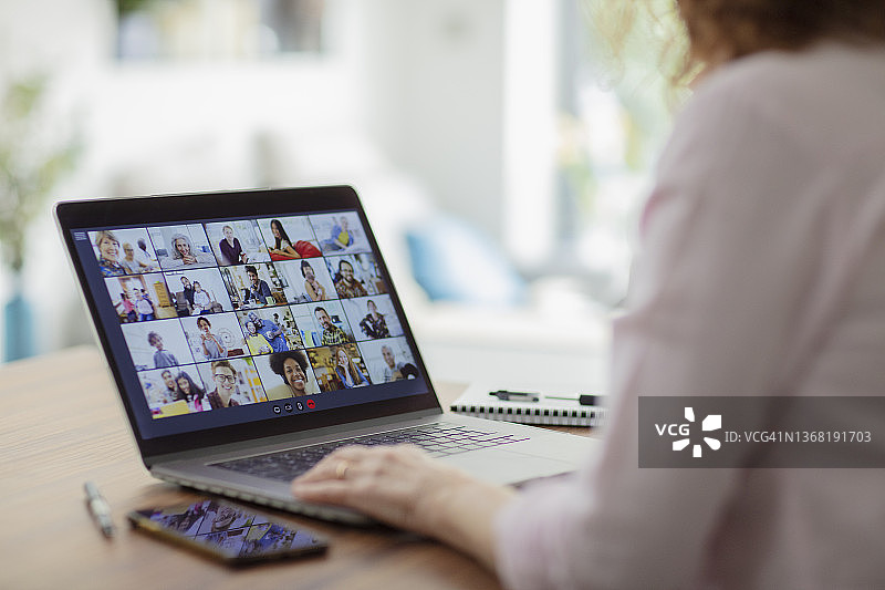 同事在笔记本电脑屏幕上进行视频会议图片素材