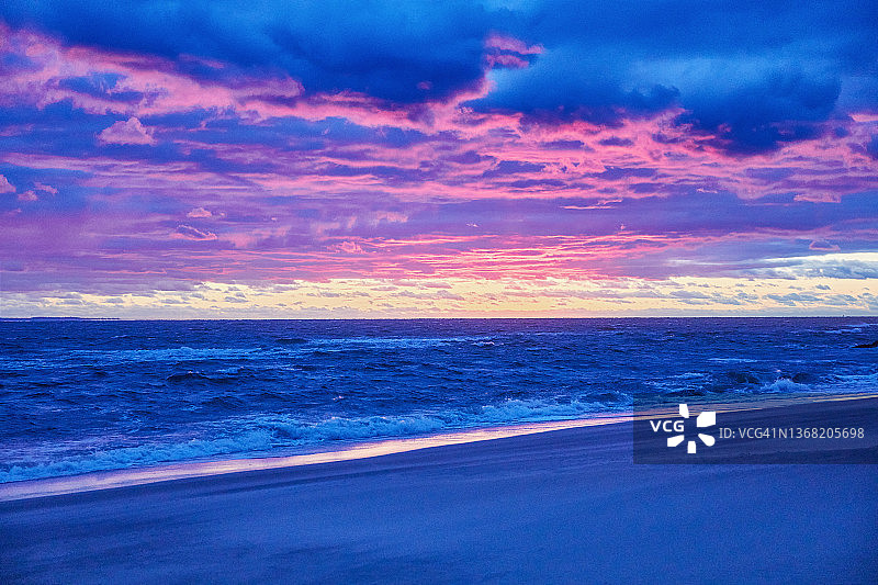 日落时分的海滩和大海，戏剧性的蓝紫色天空图片素材