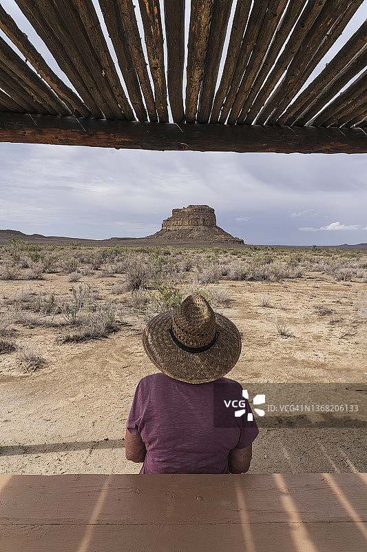 美国新墨西哥州查科峡谷国家历史公园，草帽女子眺望查科文化国家历史公园的法哈达比尤特图片素材