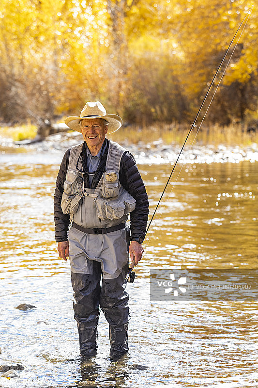 美国爱达荷州贝尔维尤：秋季在伍德河飞蝇钓鱼的年长男子肖像图片素材