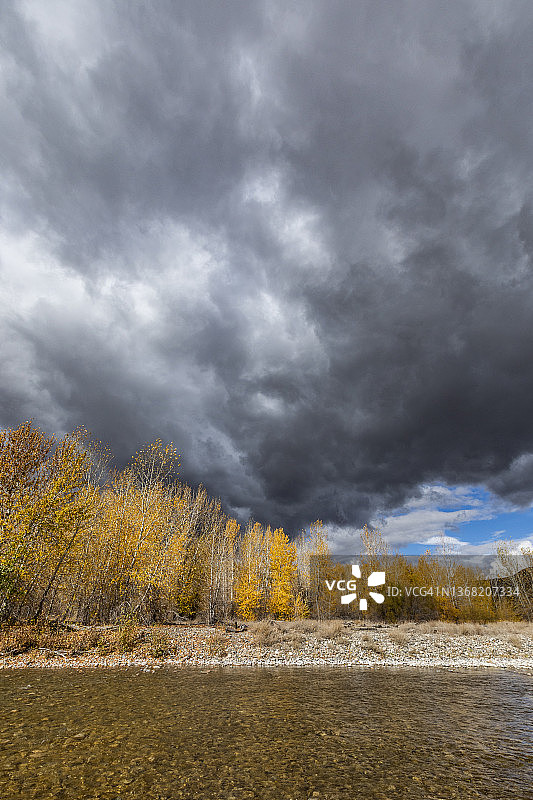 美国爱达荷州贝拉维尤秋季森林和大伍德河上空的暴风云图片素材