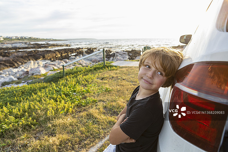 倚靠在SUV上的男孩肖像图片素材