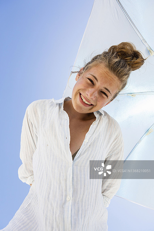 在遮阳伞下的女孩（16-17岁）的肖像图片素材