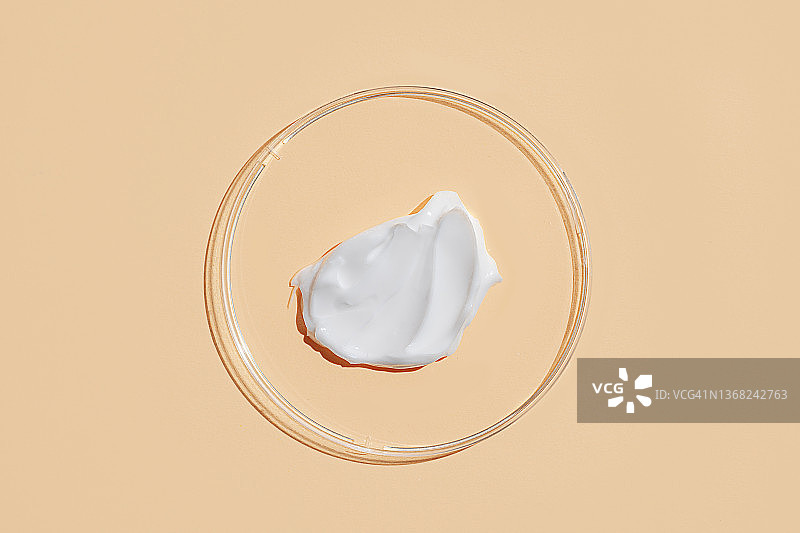 米色背景的白色凝胶和化妆品在培养皿中的涂抹图片素材