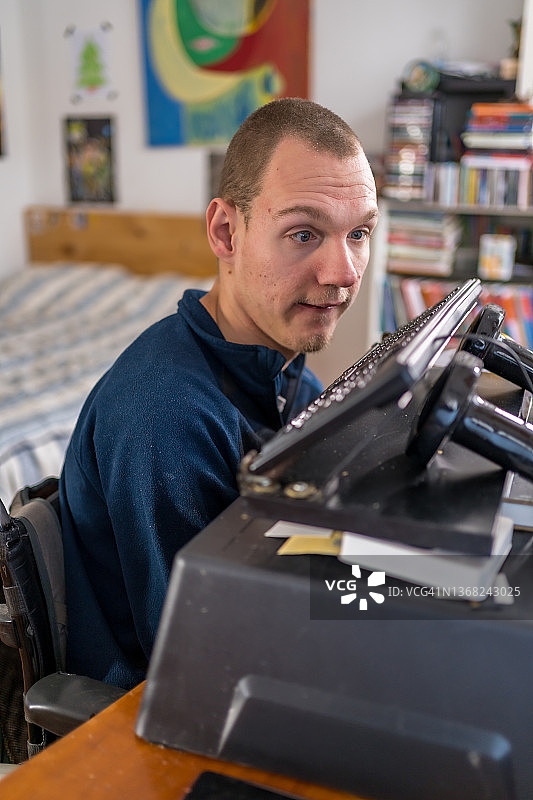 一个残疾男子用鼻子在电脑键盘上写作图片素材