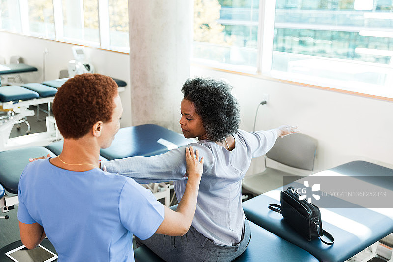 治疗师教女人肩部和手臂练习的高角度照片图片素材