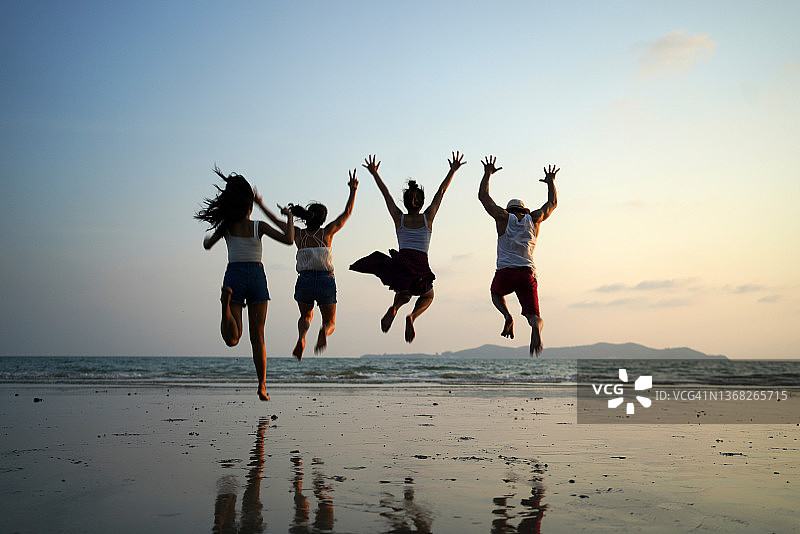 朋友们在沙滩享受夏日旅行。图片素材