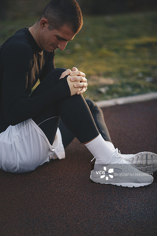 穿白色短裤的年轻男子跑步机上休息图片素材