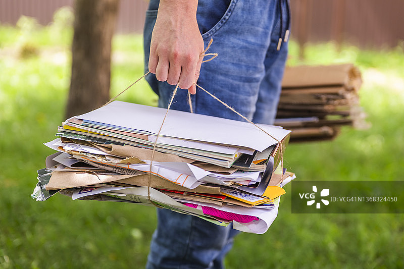 女子手持一叠纸和纸板准备回收图片素材