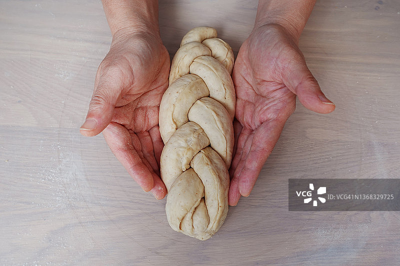 面包师的手拿着编织面包面团图片素材