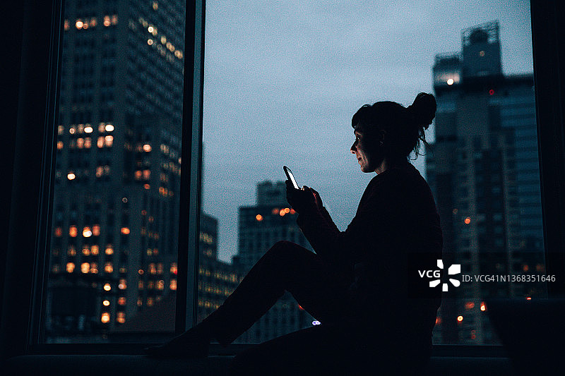坐在曼哈顿窗边的女人图片素材
