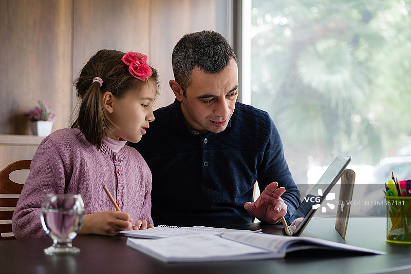 父亲辅导女儿做作业图片素材