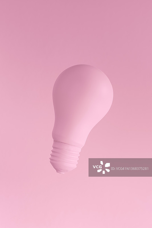 粉色背景上的粉色白炽灯泡图片素材