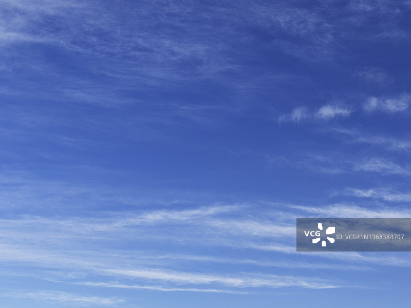 阳光明媚的蓝色天空和缕缕云絮图片素材