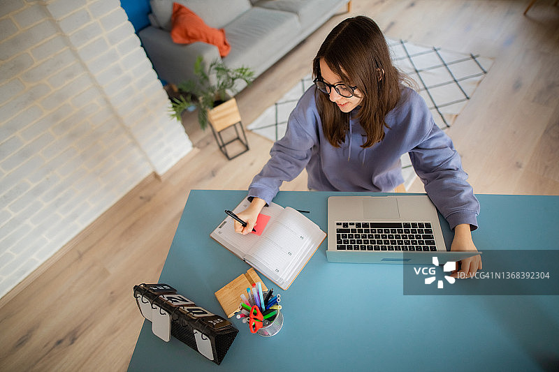 女孩上网课时做笔记图片素材