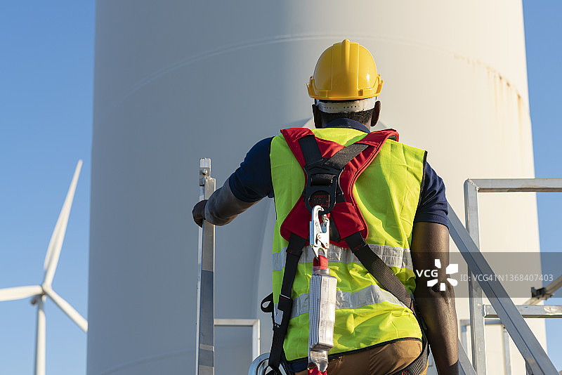 在高处作业时佩戴安全带和安全绳的建筑工人图片素材