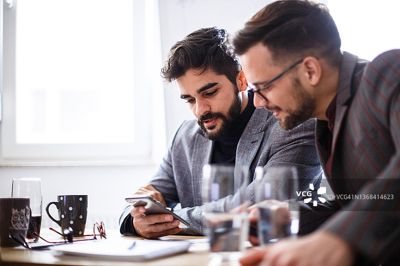 两位年轻的男士在办公室工作和交谈图片素材