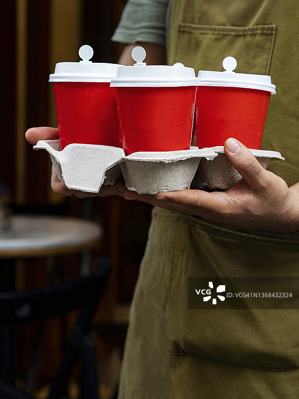 男人拿着咖啡纸杯，咖啡师端着外卖咖啡图片素材