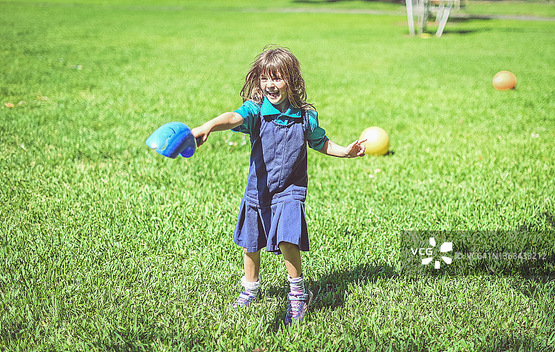 快乐的学童在操场上玩球，享受户外自由时光图片素材