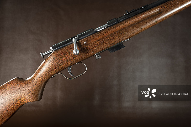 棕色皮革背景上的栓动步枪图片素材